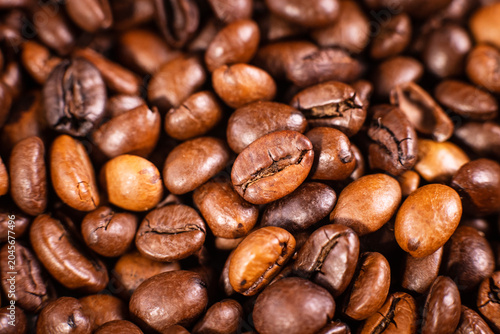 Close-up of roasted coffee beans and a coffee pod on a brown background