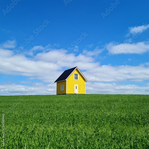 Sunny Yellow House in Green Field Under Blue Sky During Daytime Hours