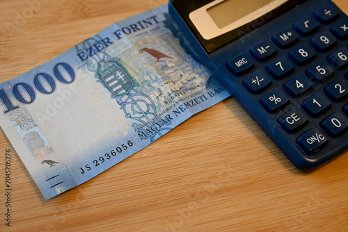 Hungarian 1000 forint banknote with calculator, symbolizing finance, accounting, and cost of living.