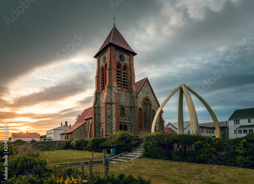 Foto Morning picture of Christ Church Cathedral with famous whalebone arch, dramatic sky and first sun rays, Port Stanley, capital of Falkland Islands, British overseas territory