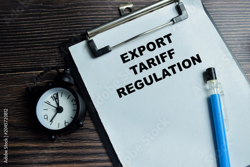Photos Concept of export tariff regulation write on clipboard isolated on Wooden Table