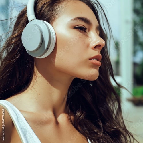 Woman Listens to Music With Headphones While Outside on a Sunny Day