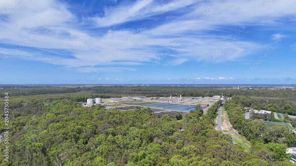 Obraz premium Aerial View of Coombabah Water Treatment Plant Surrounded by Dense Forest