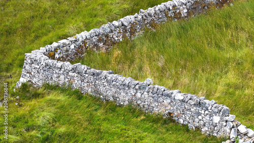 Tableau sur toile Aerial View of Ancient Stone Wall in Green Scottish Grassland