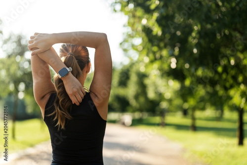 Shot of a sporty young woman stretching while standing outside.