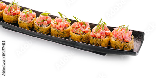 Konstfotografi Sushi rolls served on a black plate with fish and green onions on top