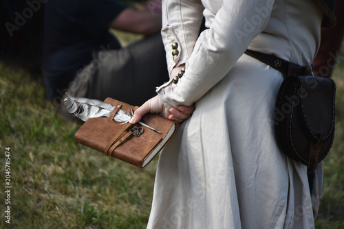 Canvastavla Traditional leather journal and quill writing set in hand of a person in a medie