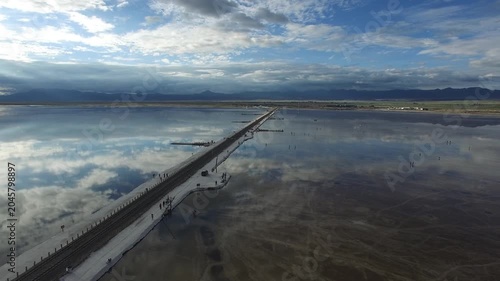 Causeway across reflective salt lake with mountain horizon