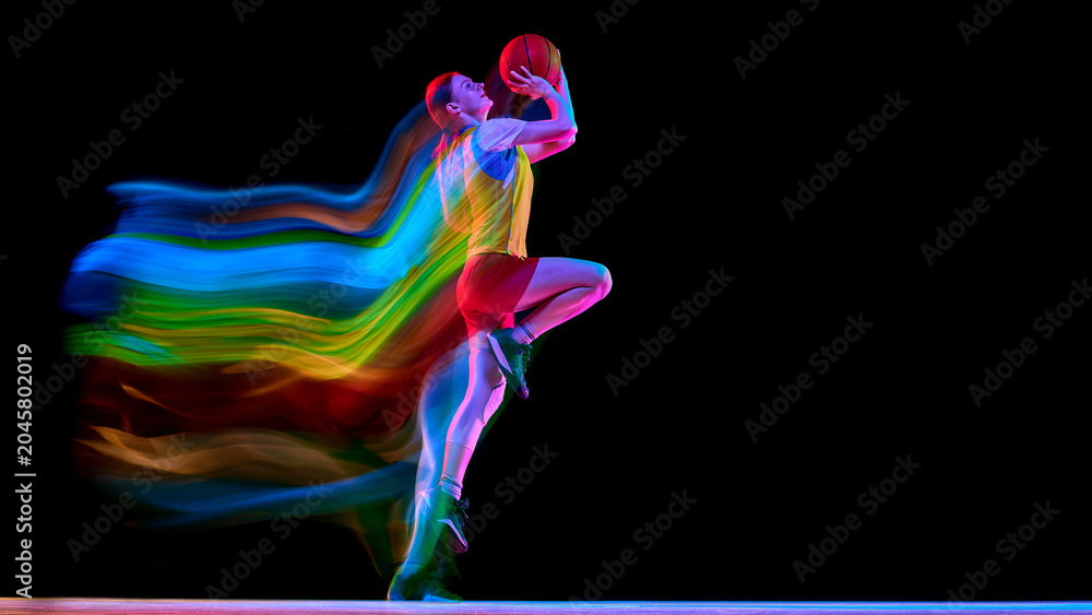 Obraz premium Female basketball player lifting ball for shot with colorful motion trail. Concept of shooting practice, performance mindset, sports poster covers, and women basketball promotion.