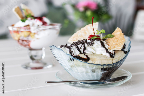 banana split ice cream sundae dessert on white table in outdoor garden cafe