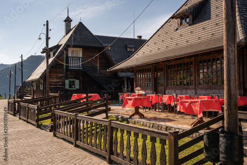 Fotografie Charming outdoor restaurant terrace with traditional wooden cabins and vibrant r