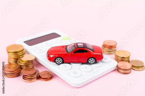 Model of car with coins and calculator on color background