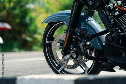 Close up of motorcycle front wheel with disc brake on sunny day