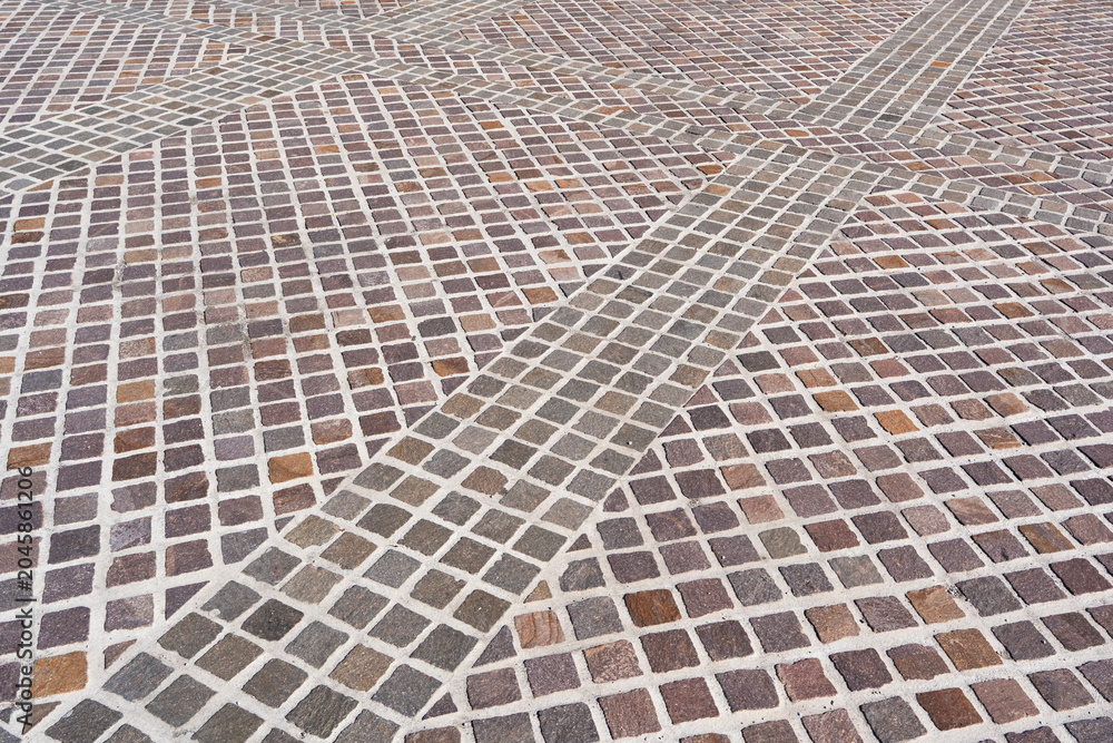 Fototapeta premium High angle view of a rustic cobblestone pavement texture with square stone blocks arranged in diagonal rows