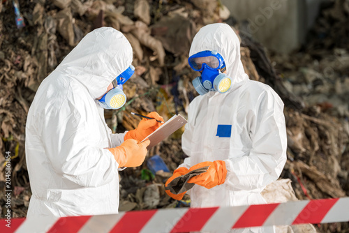 Environmental Management Inspection:Environmental specialists conducting assessment and documentation.Highlighting detailed record-keeping in hazardous waste management and environmental monitoring.