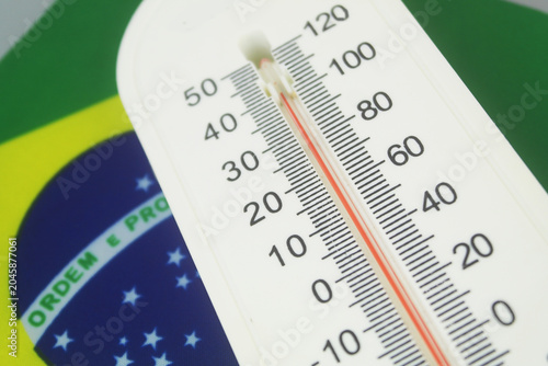 Thermometer with high temperature on flag of Brazil. Hot weather in Brazil concept.