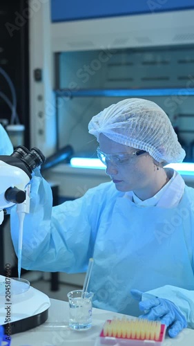 Female Scientists Working in Modern Research Laboratory with Microscope and Laptop