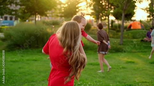 a mother and her child are walking and having fun in the park in the summer, a mother and a small child on a green lawn