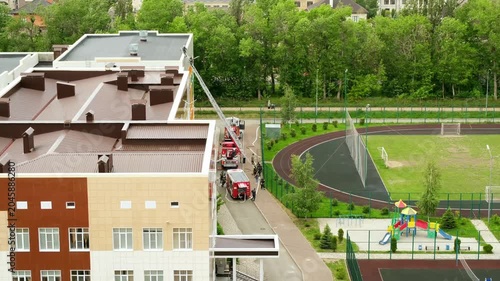 firefighters at the school, fire trucks arrived to put out the fire at the school, climbing to the roof