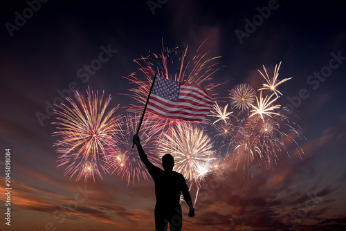 Man with National flag of United States of America in sky with fireworks