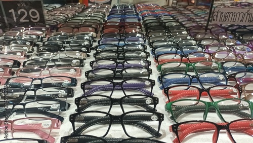 Fotografía Rows of various fashion eyeglasses and sunglasses are displayed neatly on shelves inside a brightly lit optical shop for sale