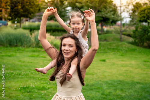 Bild auf Leinwand a mother and a child playing and having fun in a park, a mother and a baby walki