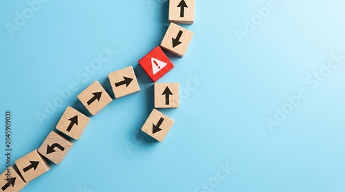 Wooden blocks with arrows showing a path and a red block with a warning sign indicating a change in direction.