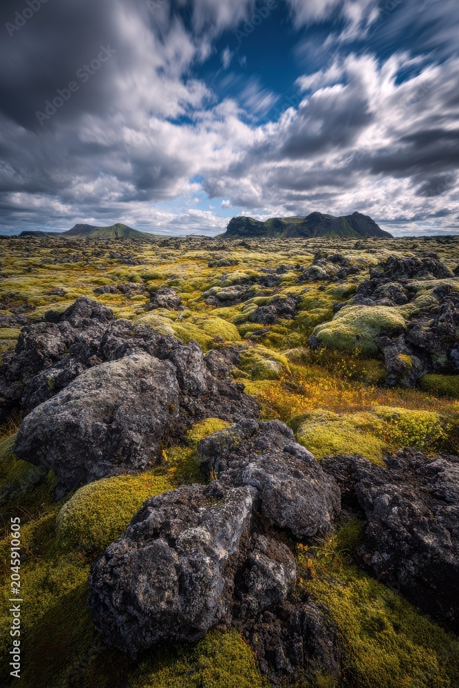 Fototapeta premium Icelandic lava field with moss-covered rocks and dramatic sky