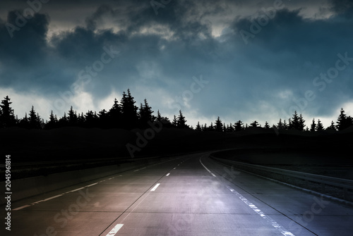 Foto Empty highway at night under storm clouds and dark sky