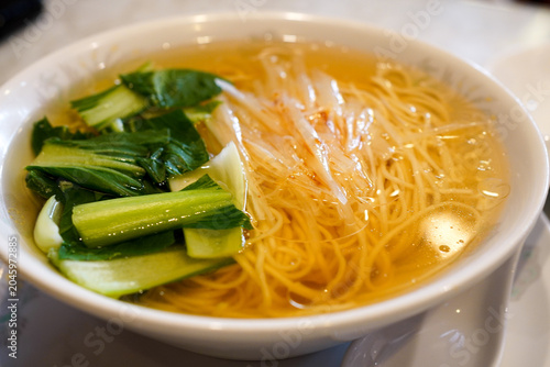 Photography Shanghai style scallion oil noodle soup topped with green vegetables