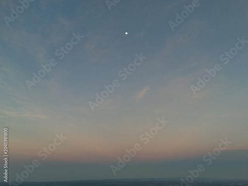 Foto A soft gradient of dusk sky over a calm horizon with a bright moon