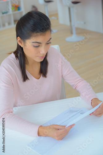 sad young woman reading letter
