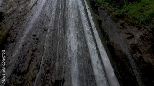 Majestic Waterfall Flowing Through Lush Green Forest in Summer
