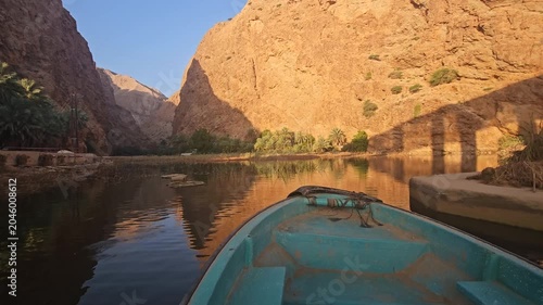 A boat sails down a river in Oman on a calm morning. Wadi Shab in Oman. Wad Shab is iconic tourist spot in Oman