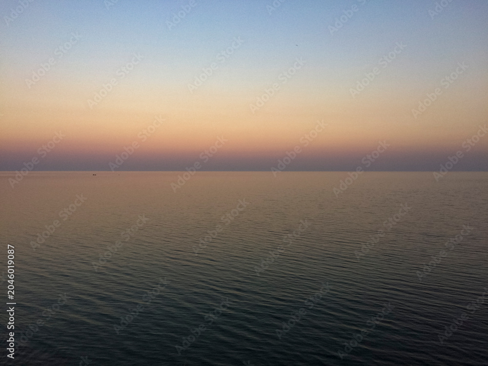Fototapeta premium Serene ocean view at sunset with calm waters and gradient sky 