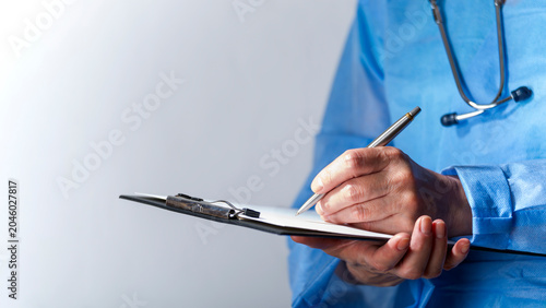 Female caucasian doctor filing papers in clipboard. Healthcare background with copy-space