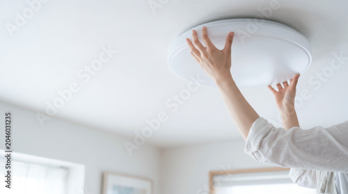 シーリングライトの取り付け LED電球や蛍光灯を交換をする女性
