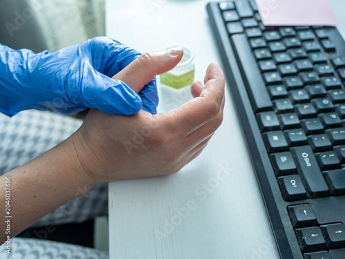 Treating thumb tendon pain beside keyboard in home office workspace