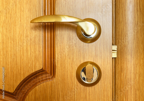 Fotografía Close-up of brass door handle and privacy lock on natural wooden interior door