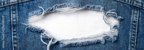 Ripped blue denim jeans texture with white background hole.