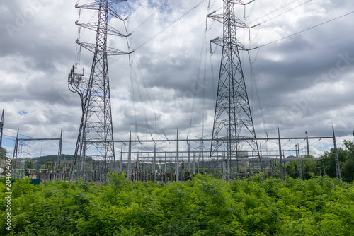High voltage power lines and electrical towers against a dramatic cloudy sky