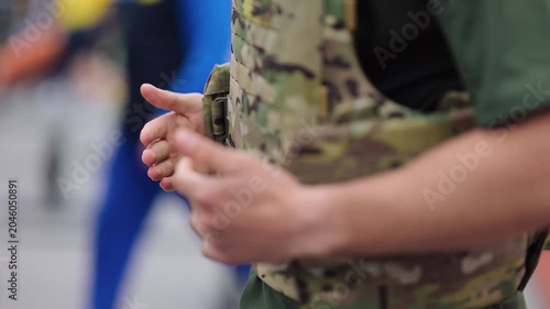 Soldier preparing equipment and adjusting vest at military training
