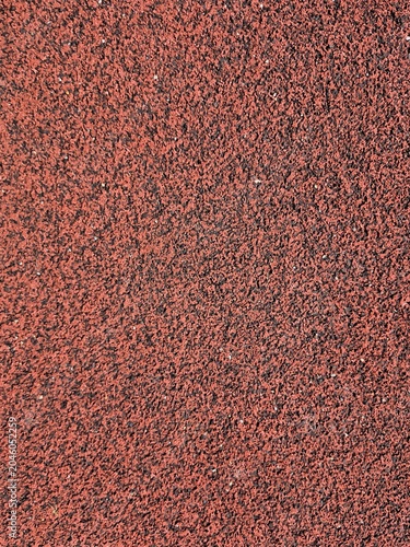 Red rubber running track surface texture background athletics stadium flooring closeup