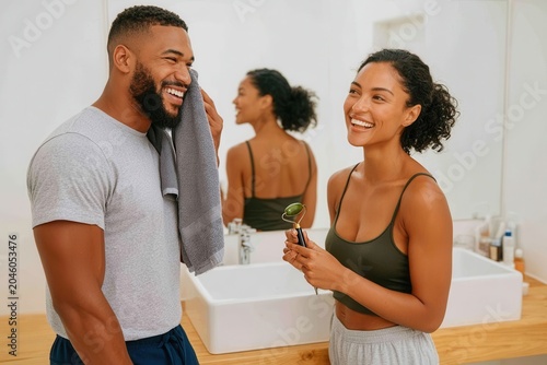 Happy couple enjoying a morning skincare routine together in a bright home bathroom