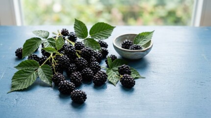 Blackberries with leaves lying on a blue surface, fresh berry food photography with ripe fruit, healthy eating, organic produce, natural vitamins, colorful summer dessert ingredient, clean tabletop,