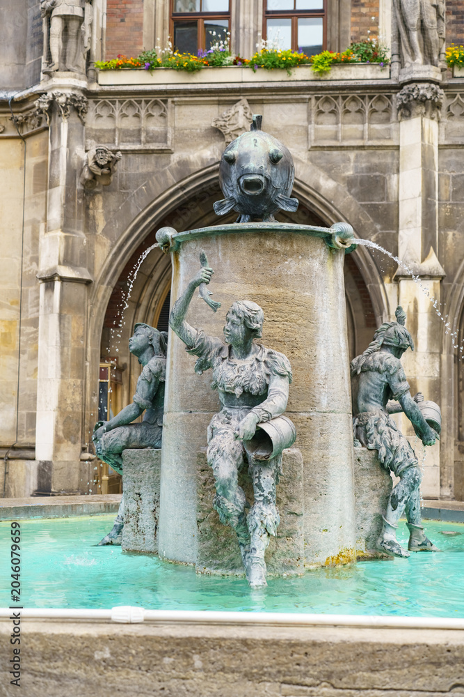 Obraz premium Historic fish fountain sculpture at Marienplatz in Munich with Gothic architecture backdrop