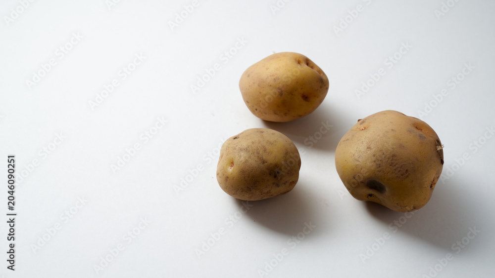 Fototapeta premium Three Potatoes Clustered on White Background