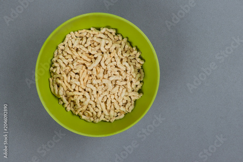 Bol verde de bambú lleno de proteina de guisante texturizada sobre fondo gris