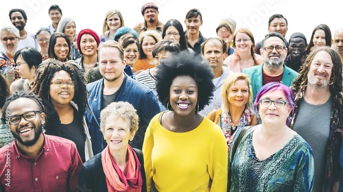 Inclusive diverse crowd of adults from various backgrounds smiling at the camera, ideal for corporate social responsibility and community assets