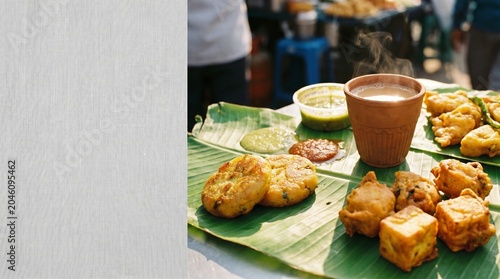 Traditional indian street food served on a banana leaf with hot chai